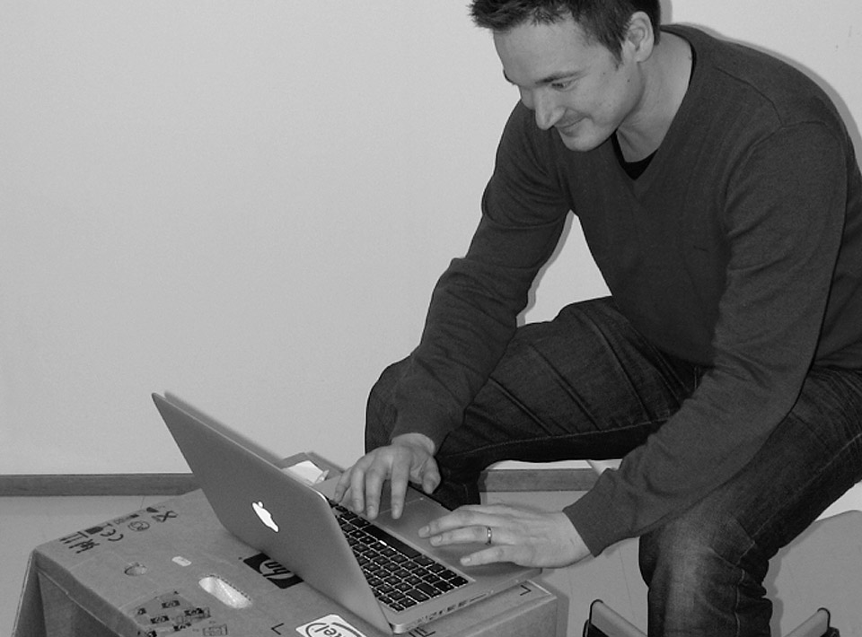 2010 Ilkka sitting at his cardboard desk at the Espoo office